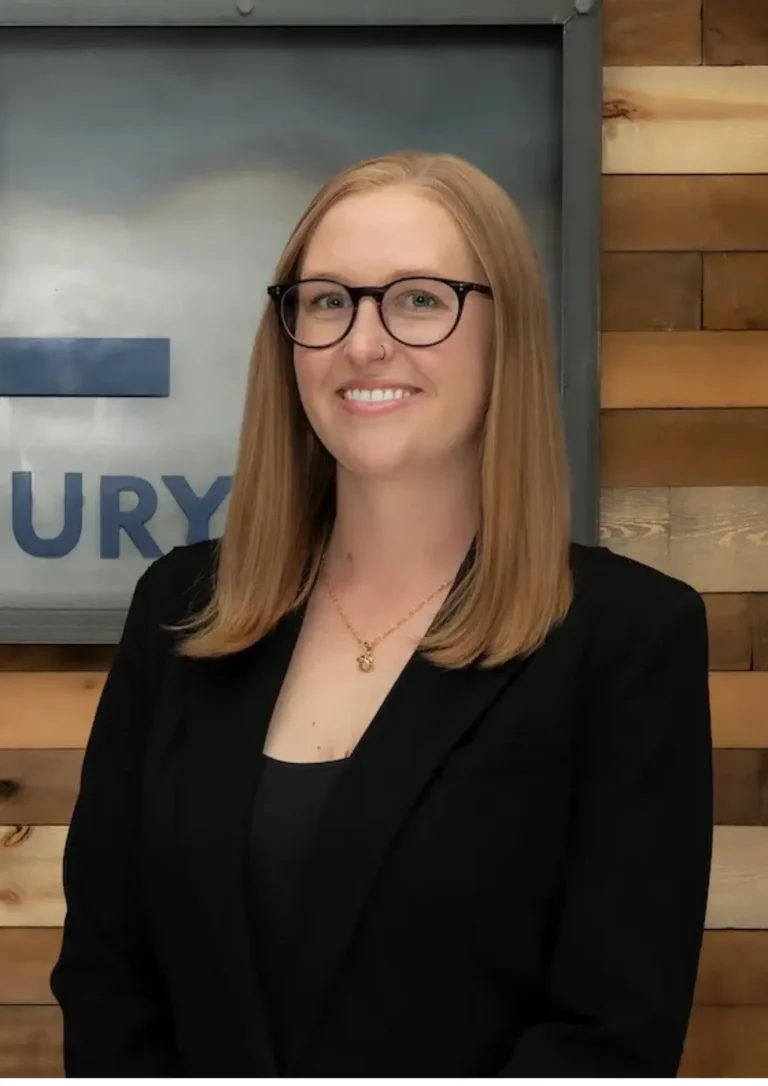 Professional portrait of a Malnar Law legal team member with glasses and a black blazer, representing expert personal injury legal services in Colorado.