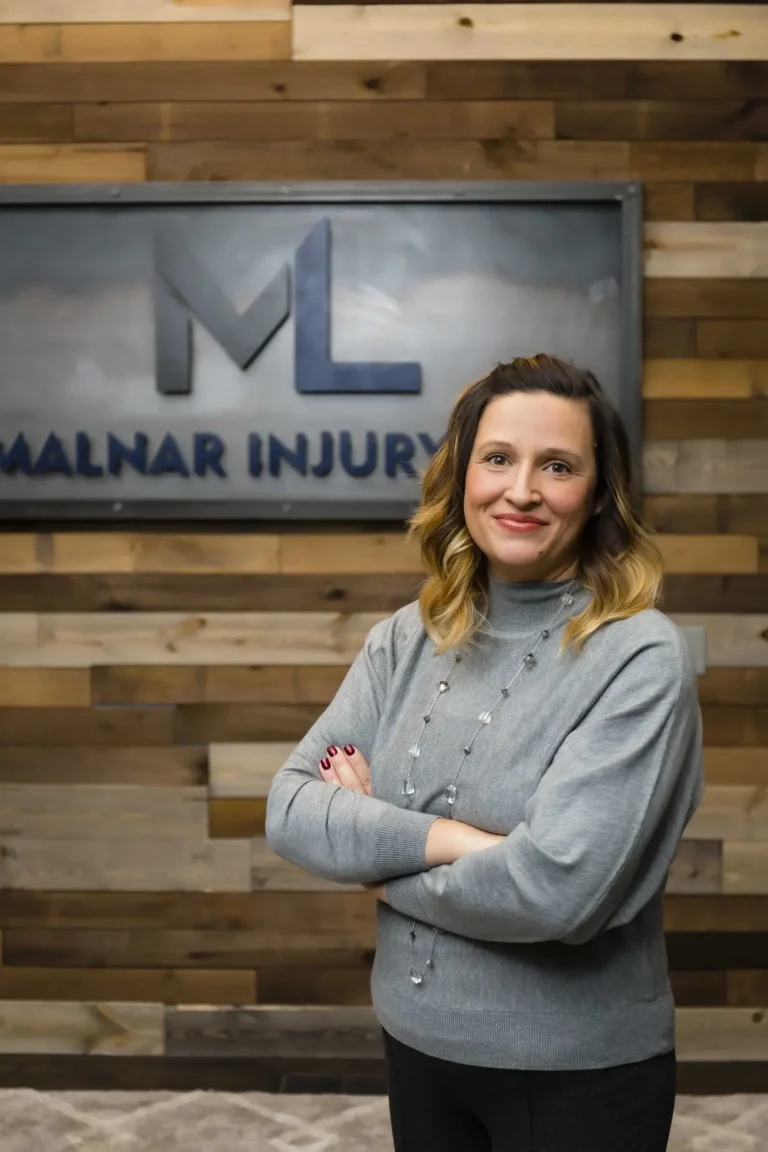 Professional portrait of a Malnar Law legal team member in front of the firm's office sign, symbolizing expert personal injury representation.