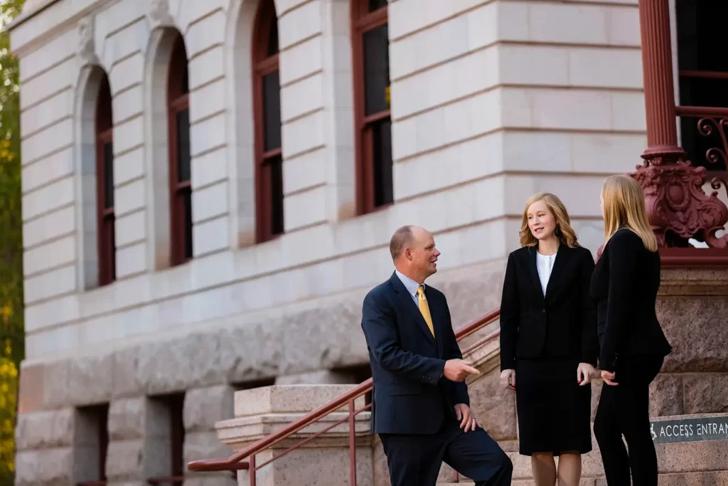 Personal injury attorney Ryan Malnar and his legal team at Malnar Law stand smiling on the steps of the historic courthouse in Pueblo, Colorado, ready to represent clients.