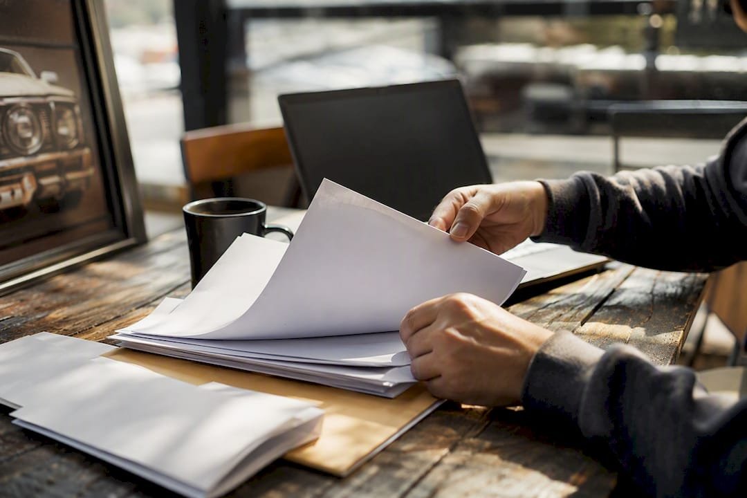Hands sorting medical bills on table
